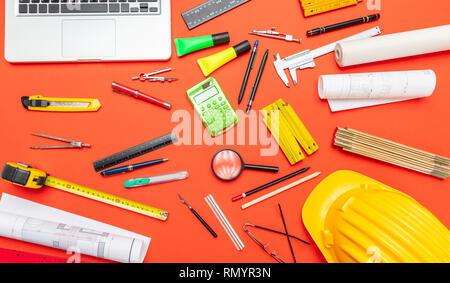 Architekt Ingenieur Baustelle Büro Schreibtisch. Projektentwürfe, Schutzhelm und Computer Laptop auf orange Farbe, Ansicht von oben Stockfoto