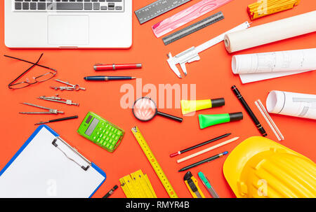 Architekt Ingenieur Baustelle Büro Schreibtisch. Projektentwürfe, Schutzhelm und Computer Laptop auf orange Farbe, Ansicht von oben Stockfoto