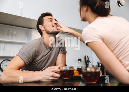 Foto von adorable Paar Mann und Frau am Tisch sitzen und frühstücken zusammen Stockfoto