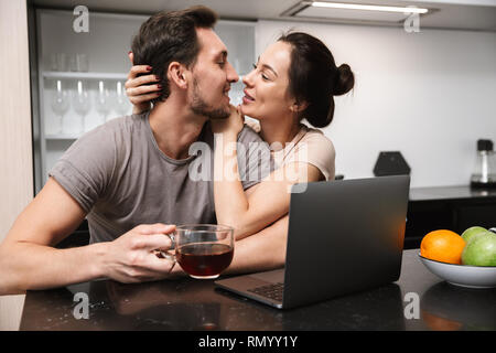 Foto von erstaunlichen Paar der Mann und die Frau in der Küche sitzt und mit Laptop während der gemeinsamen Fruehstueck Stockfoto