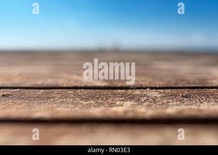 Leere natürlichen hölzernen Tisch Hintergrund Schuß an eine sehr kurze Schärfentiefe mit rustikalen Meer gekehrt Holzbohlen auf einer tropischen Karibik Strand wa Stockfoto
