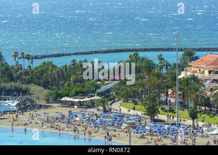 LOS CRISTIANOS, Teneriffa, Kanaren, Spanien 2014 16. November: Blaue Sonnenschirme und Sonnenliegen sind auf städtischen Küste. Berühmten städtischen Strände mit feinem Sand sind o Stockfoto