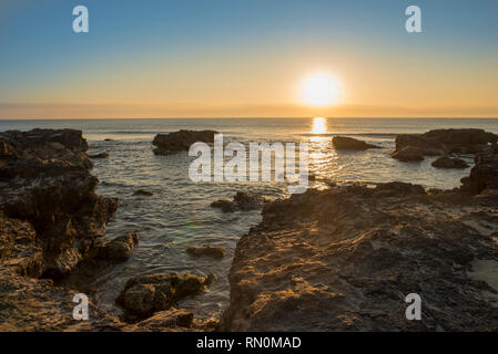 Ein Sonnenaufgang zwischen den Felsen von Oropesa del Mar, Spanien Stockfoto
