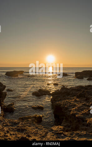 Ein Sonnenaufgang zwischen den Felsen von Oropesa del Mar, Spanien Stockfoto