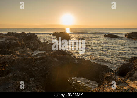 Ein Sonnenaufgang zwischen den Felsen von Oropesa del Mar, Spanien Stockfoto