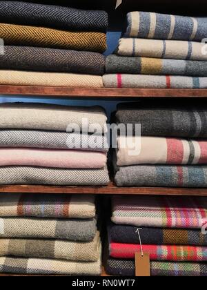 Blumenstrauß aus warmen gestrickten Pastellfarben der verschiedenen Stoffdessins in einem Stapel auf Weiß. Herbst Winter saison modische Strickwaren. Stockfoto
