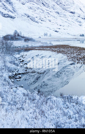 Snowy Achtriochtan Reflexionen in Loch Ness, Glencoe, Scottish Highlands, Schottland Großbritannien im Januar Stockfoto