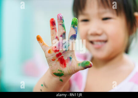 Glücklich und nettes Mädchen verwendet die Hände und Finger für Finger Malerei Kunstwerk. Bild für Konzept von Schule, Kunstfach und Spiel. Stockfoto