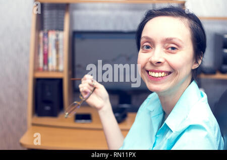 Freudige und schöne Frau genießt die Arbeit im Büro durchgeführt. Stockfoto