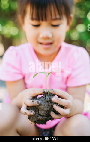 Nettes Kind Pflanzen einen Baum für Hilfe, um die globale Erwärmung oder den Klimawandel zu verhindern und die Erde zu retten. Nachhaltiges Wohnkonzept. Stockfoto