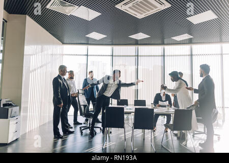 Interracial Partner streiten Während team building Training treffen, Kaukasische wütend Büroangestellter mit arabischen Kollegen, dunkelhäutige Ein Stockfoto