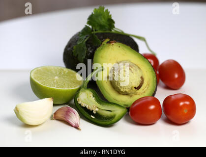 Guacamole Zutaten, die in einem Leben immer noch Foto. Das Foto mit Avocado, Tomaten, Koriander, Limette, jalapeno, Zwiebel und Knoblauch Handschuhe. Lecker! Stockfoto