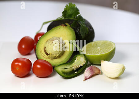 Guacamole Zutaten, die in einem Leben immer noch Foto. Das Foto mit Avocado, Tomaten, Koriander, Limette, jalapeno, Zwiebel und Knoblauch Handschuhe. Lecker! Stockfoto