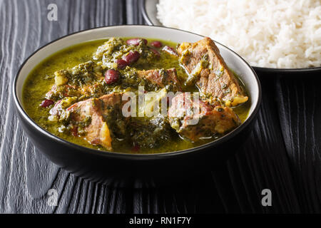 Frisch zubereitete Ghormeh Sabzi Lamm Eintopf Fleisch mit Kräutern und Bohnen close-up in eine Schüssel und Reis auf dem Tisch. Horizontale Stockfoto