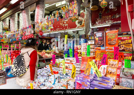 Tel Aviv-Yafo, Carmel Markt, Israel - 28. Dezember 2018: Verkäufer in der Sweet Candy shop Winken, der Kunde, der sich von der großen Auswahl wählt interagieren Stockfoto