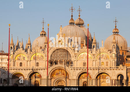 Basilika San Marco bei Sonnenuntergang, Venedig, Venetien, Italien mit einem goldenen Licht und den Fokus auf die obere Hälfte der Kathedrale mit den Mosaiken und Kuppeln Stockfoto