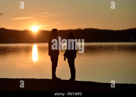 München, Deutschland. 16. Februar 2019, Bayern, München: Wanderer genießen die letzten Strahlen der untergehenden Sonne im Starnberger See. Foto: Angelika Warmuth/dpa Stockfoto