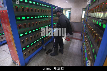 Datong, Shanxi, China. 12 Dez, 2018. Eine Chinesische coal Miner prüft seinen Kopf - Lampe in seinem Schließfach in der "Leuchte Haus' zum Aufladen und die Registrierung seiner Lage nach Beendigung seiner Verschiebung in Datong, Provinz Shanxi (China Kohle Land), am 12. Dezember 2018. China ist der größte Produzent und Verbraucher von Kohle in der Welt und ist damit der führende Verursacher von Treibhausgasen aus Kohle. China brennt viel mehr Kohle als berichtet, das seither in der Klimapolitik zu erschweren. Credit: Stephen Rasierer/ZUMA Draht/Alamy leben Nachrichten Stockfoto