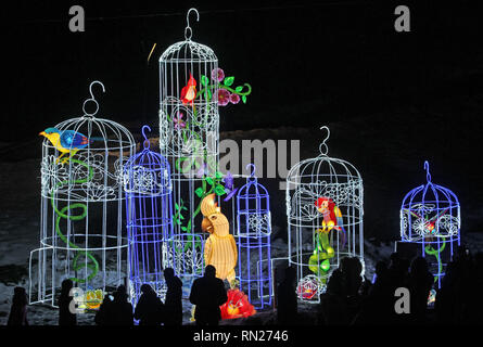 Kiew, Ukraine. 16 Feb, 2019. Menschen gesehen auf Laternen Installationen während 'Giant Chinesische Laternen Festival" am Gesang Feld in Kiew. 15 tausend Glühbirnen und mehr als zwei Kilometer von Seide sind für 30 riesige Lichtinstallationen, von denen jede symbolisiert einen alten Volksmärchen oder Legende von China verwendet. Das Festival der riesigen chinesischen Laternen ist einer der bekanntesten Ausstellungen in der Welt, die in mehr als 40 Ländern abgehalten wurde, so die Veranstalter. Credit: Pavlo Gontschar/SOPA Images/ZUMA Draht/Alamy leben Nachrichten Stockfoto