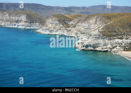 In der Umgebung des schönen Ferienort Agua Amarga in Cabo de Gata Naturpark (Spanien) sind fantastische Klippen mit Höhlen in den Felsen gehauen. Stockfoto