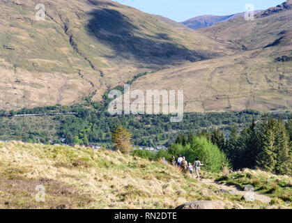 Argyll, Schottland - Mai 14, 2016: Wanderer Abstieg von Ben Arthur Berg, während ein Güterzug Pässe Arrochar auf der West Highland Line Eisenbahn in Th Stockfoto