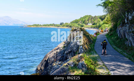 Appin, Schottland, Großbritannien - Mai 12, 2016: ein Radfahrer fährt entlang des National Cycle Network Caledonia Weg auf einem umgebauten Rail Trail entlang der Küste von Appi Stockfoto