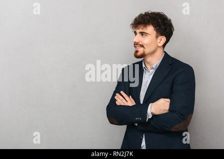 Bild von einem gutaussehenden jungen Geschäftsmann über graue Wand Hintergrund isoliert. Stockfoto