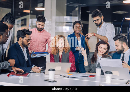 Die Suche nach neuen Erkenntnissen und geniale Ideen. Mixed-Race Gruppe von neun unterschiedlichen Menschen surfen im Netz und suchen durch Dokumente während der Sitzung am Stockfoto