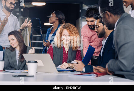 Die Suche nach neuen Erkenntnissen und geniale Ideen. Mixed-Race Gruppe von neun unterschiedlichen Menschen surfen im Netz und suchen durch Dokumente während der Sitzung am Stockfoto