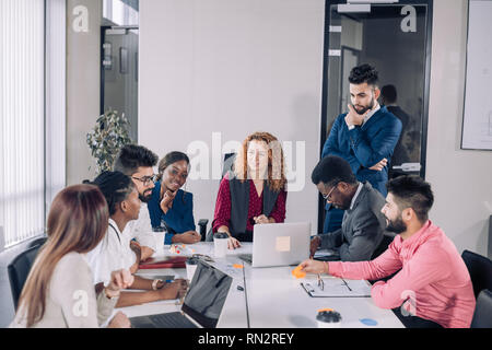 Gemischtrassiges Team junger diverse Mitarbeiter weitergeben von Ideen, wie die Firma Einkommen zu erhöhen, wird im Brainstorming beteiligt Stockfoto