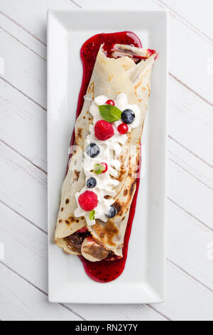 Europäische Pfannkuchen, süßen Crepe mit Topping auf weißen langen Platte Stockfoto