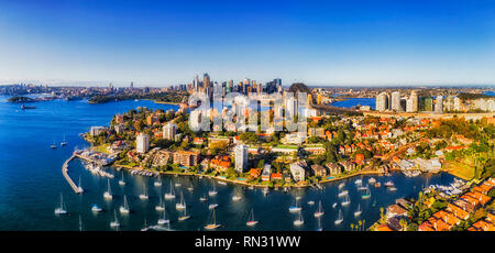 Kleine blaue Bucht mit Marina und Yacht Club Pier auf der Uferpromenade von Sydney Harbour gegen große Stadt Sydney CBD Wahrzeichen in erhöhten Luftaufnahme über r Stockfoto