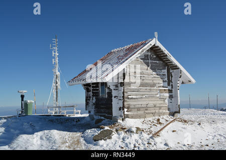 Kleines Haus anmelden, gefroren Antenne, ein paar Bänke, Mülleimer und Spion anzeigen Maschine auf der Spitze des Berges im Winter Stockfoto