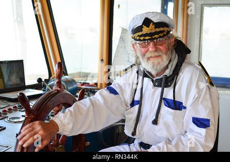 Schiff Navigation, erfahrenen Kapitän, alte Meer Hund mit grauem Haar und Bart in Schiff navigation Kabinen, lächelnd und nach Job zufrieden gemacht Stockfoto