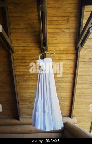 Hochzeit Kleid auf einem Haken auf einer hölzernen Abdeckung Stockfoto