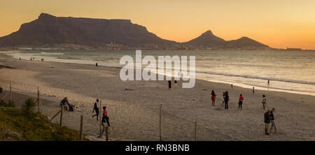 Kapstadt hat viele schöne Strände, an denen sich Gäste und Einheimische ein Spaziergang am Strand geniessen, wie Sunset Beach, Cape Town, Western Cape, Südafrika. Stockfoto