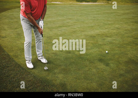 Männliche Golfspieler auf Putting Green und den Schuß. Ältere Golf Spieler setzen auf Grün. Stockfoto