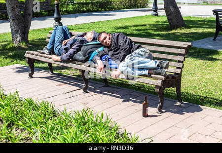 Samara, Russland - 6. Mai 2018: Obdachlose schläft auf der Holzbank im City Park Stockfoto