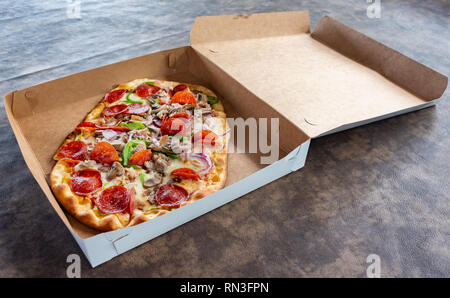 Pizza mit verschiedenen Toppings im Lieferumfang box Stockfoto