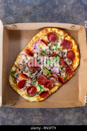 Pizza mit verschiedenen Toppings im Lieferumfang box Stockfoto