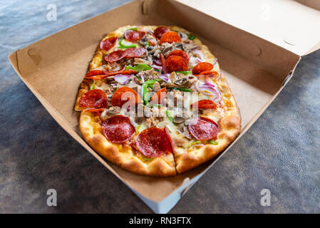 Pizza mit verschiedenen Toppings im Lieferumfang box Stockfoto