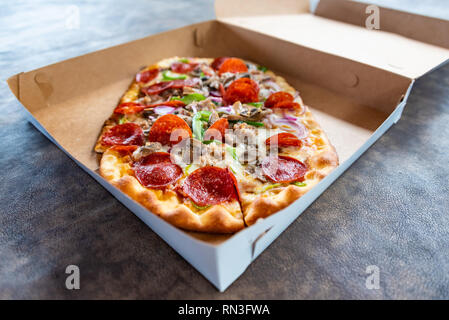 Pizza mit verschiedenen Toppings im Lieferumfang box Stockfoto