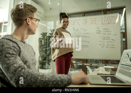 Afrikaner - junge Lehrerin lächelnd, während im Gespräch mit Studenten Stockfoto