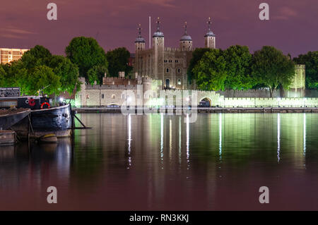 London, England, UK - 15. Juni 2011: Verräter Tor und der Weiße Turm der Tower von London sind nachts am Ufer der Themse beleuchtet. Stockfoto