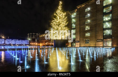 London, England, UK - Dezember 20, 2018: ein Weihnachtsbaum ist in der Nacht in Grannary Platz außerhalb Central Saint Martin's College der Universität beleuchtet Stockfoto