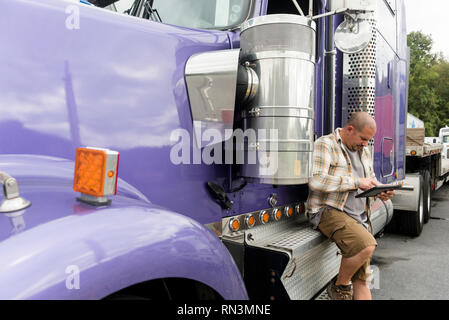 Lkw-Fahrer arbeiten an digitalen Tablet von seinem Sattelschlepper Stockfoto