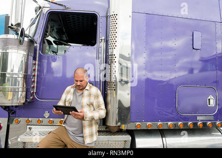 Lkw-Fahrer arbeiten an digitalen Tablet von seinem Sattelschlepper Stockfoto