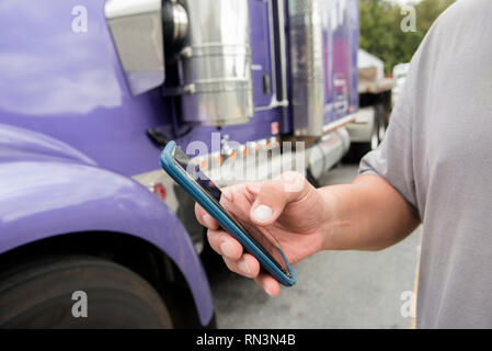 Hand der LKW-Fahrer mittels Smart Phone Stockfoto