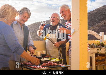 Genießen Gruppe erwachsener Kaukasier, die Freundschaft zusammen Essen und Kochen mit Grill im Freien - Konzept mit Leuten die Spaß-Co feiern Stockfoto