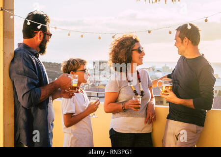 Gruppe der mittleren Alter Menschen kaukasischen Männern und einer Frau zusammen trinken auf der Terrasse mit Blick auf die Stadt, das Spaß und Freundschaft - blonde Kind mit Ihnen - Aus Stockfoto